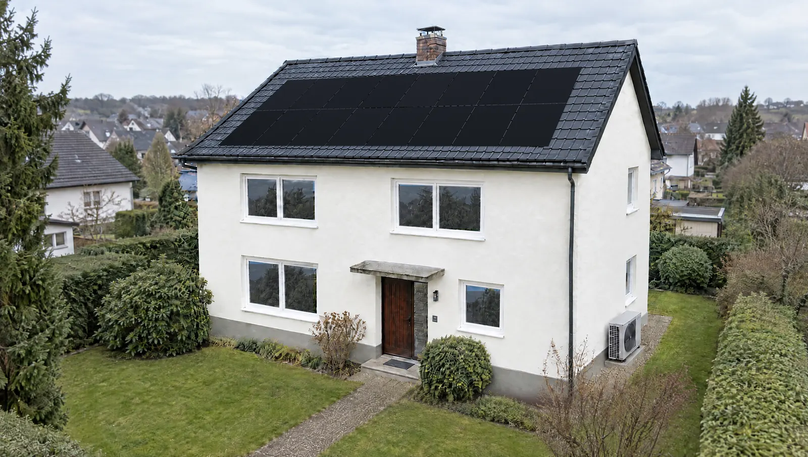 Das Haus nach der Sanierung mit neuen Fenstern, gedämmter Fassade, neuem Dach, Photovoltaik und Wärmepumpe